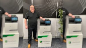 Julian Pearson, standing with a Lexmark xc4352 printer.