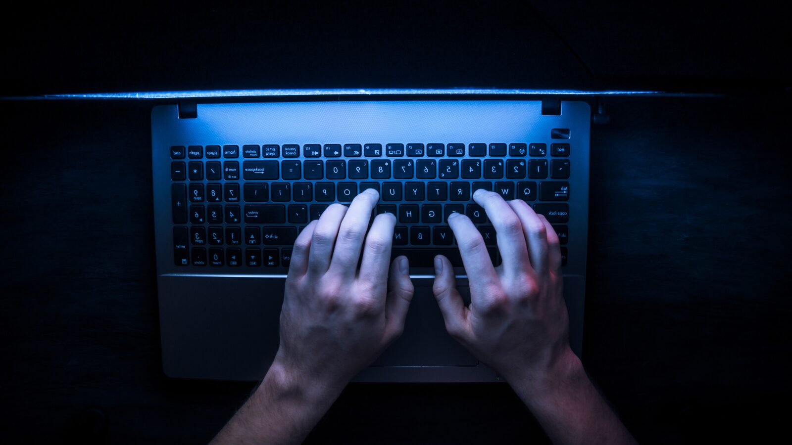 a person using a laptop in a dark room